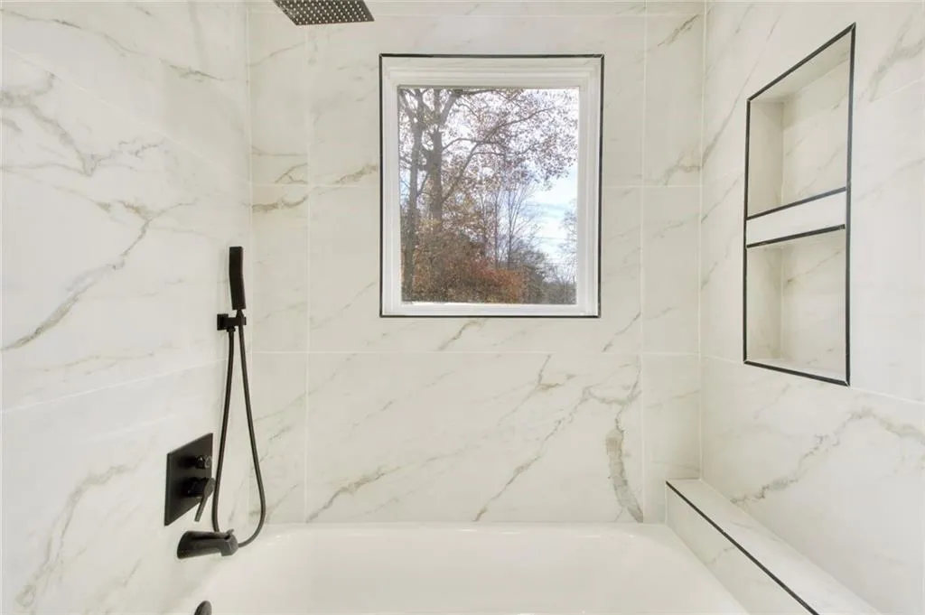 Bathroom with a combined bath / shower with marble appearance