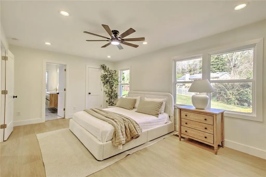 Bedroom with recessed lighting, light wood finished floors, a ceiling fan, and ensuite bath