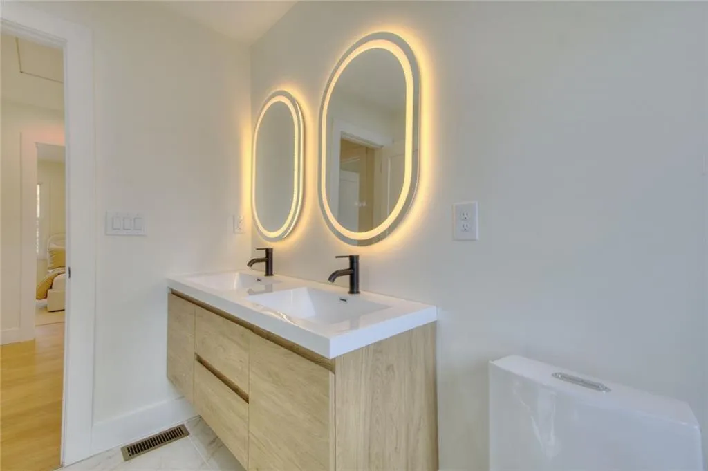 Full bathroom featuring double vanity and toilet