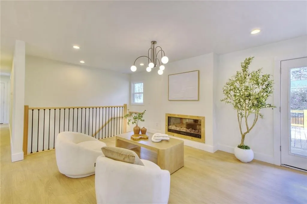 Sitting room featuring recessed lighting, light wood-style floors, and a glass covered fireplace
