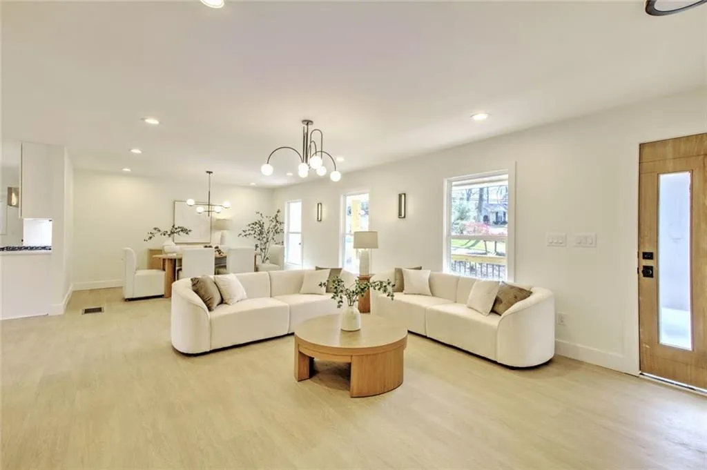 Living area with a chandelier, light wood-style flooring, and recessed lighting