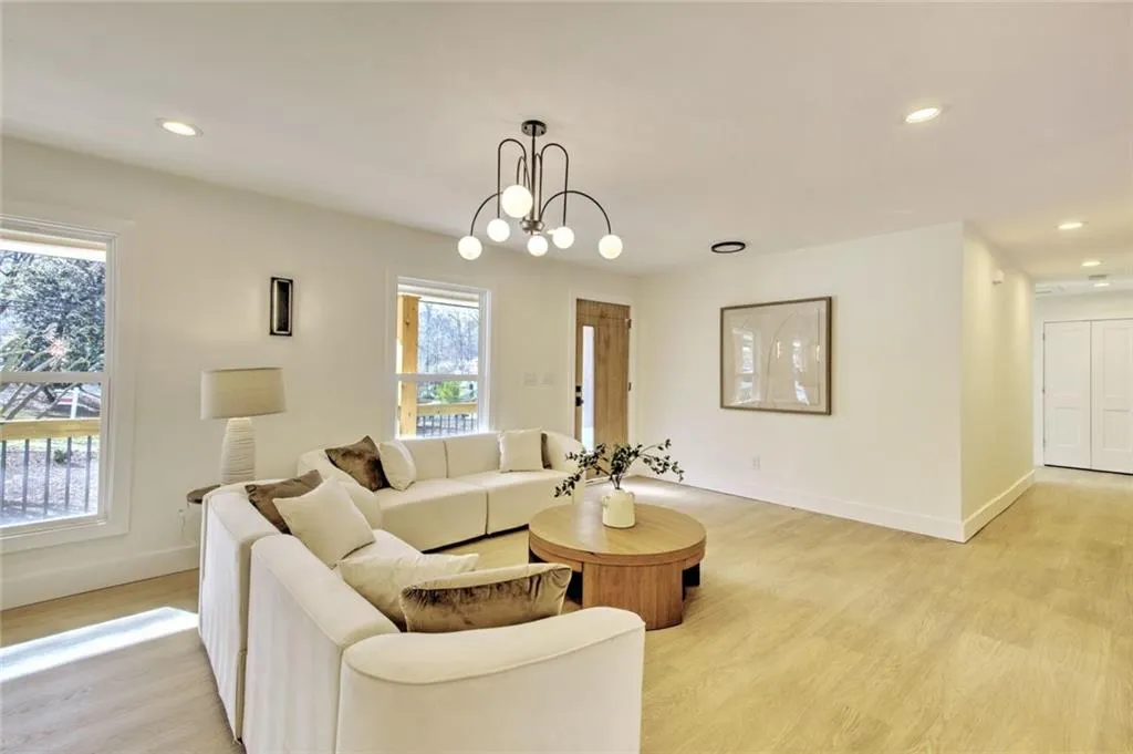 Living room featuring recessed lighting, light wood-style floors, and a chandelier