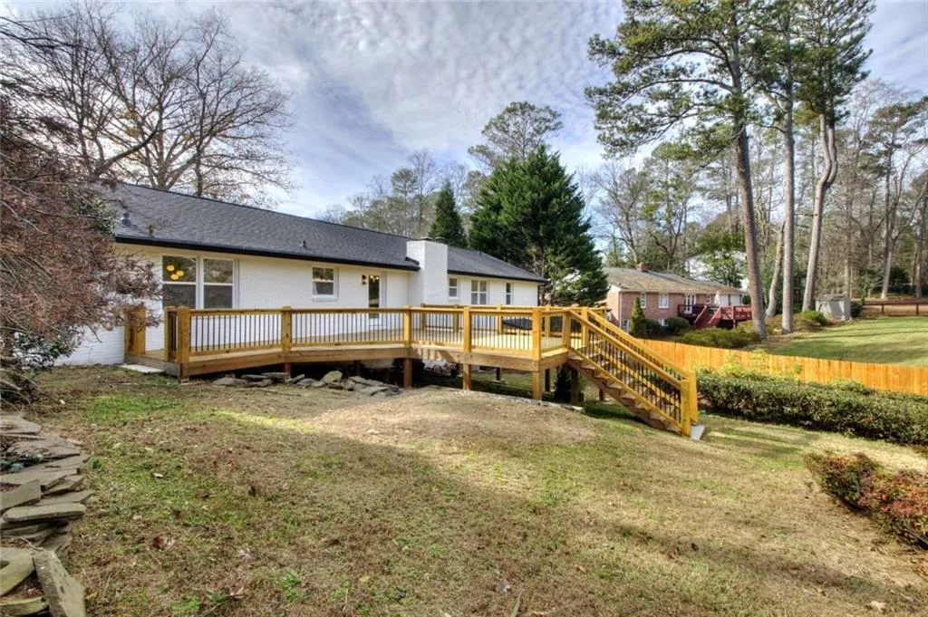 Back of property featuring a wooden deck and stairs