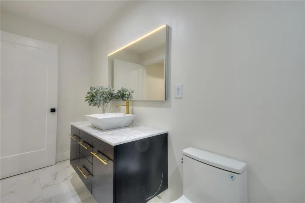 Half bath with light marble finish flooring and vanity