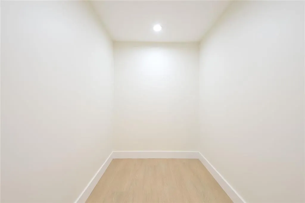 Empty room with light wood-style floors and recessed lighting