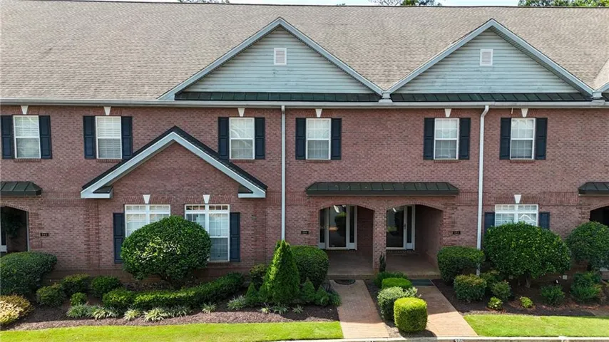 Brick exterior with architectural shingles, front gables, and dark shutters
