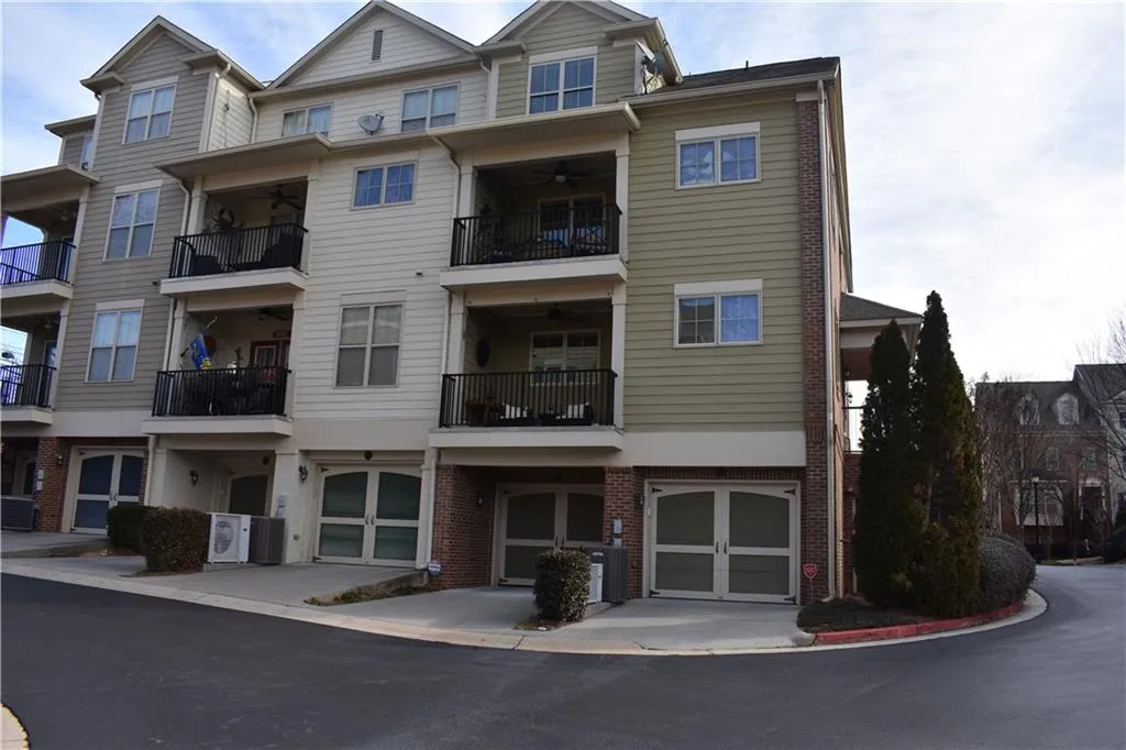 View of property with central AC unit and a garage