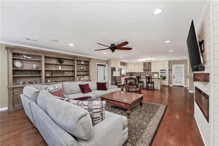Open-concept living space featuring wood-finish flooring, recessed lighting, and a ceiling fan