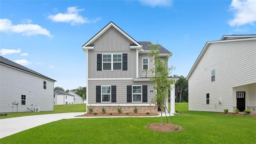 Two-story residence featuring a combination of vertical and horizontal siding, dark shutters, and a covered entry