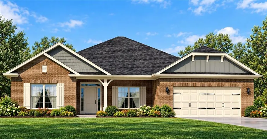 Brick facade with decorative gables, a covered entry, an attached two-car garage, and established landscaping
