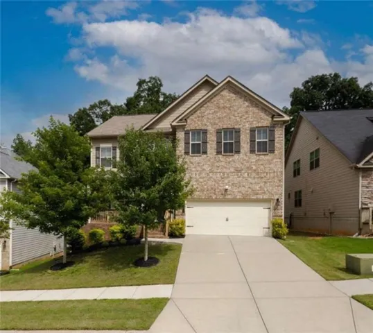 Brick and siding exterior featuring a two-car garage