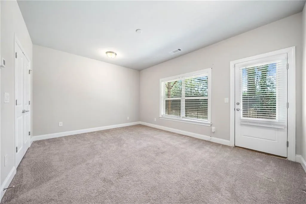 Spare room with light carpet and baseboards
