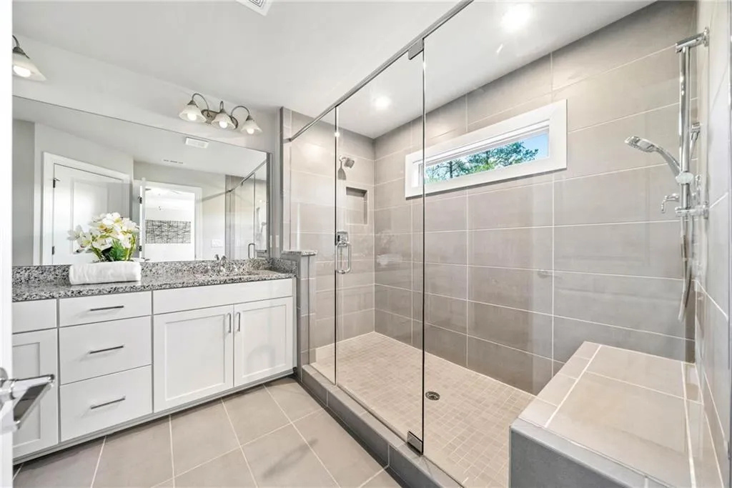 Full bathroom featuring vanity, a shower stall, light tile patterned floors, and recessed lighting