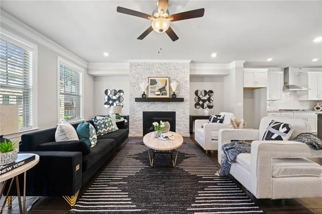 Living room featuring a fireplace, ornamental molding, a ceiling fan, recessed lighting, and dark wood-style floors