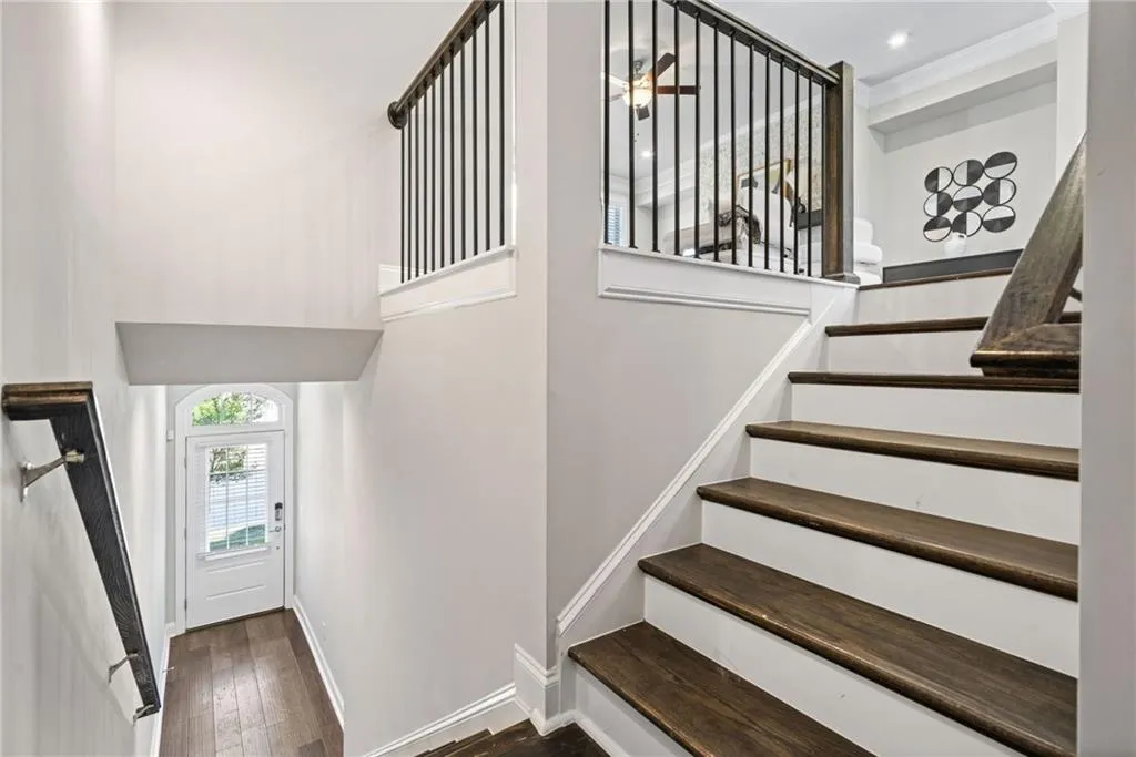 Staircase featuring hardwood / wood-style flooring and a high ceiling