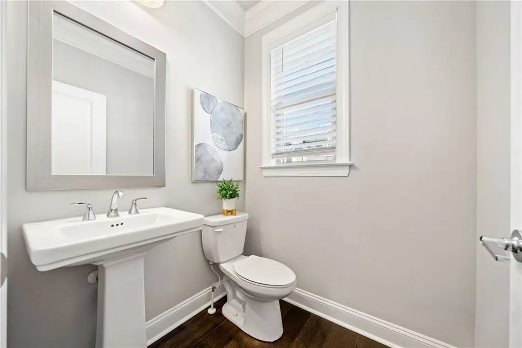Bathroom featuring dark wood-style flooring and crown molding