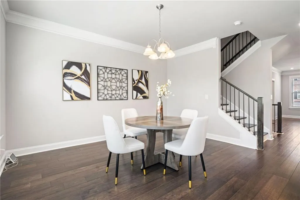Dining room featuring crown molding, stairway, dark wood finished floors, and a chandelier