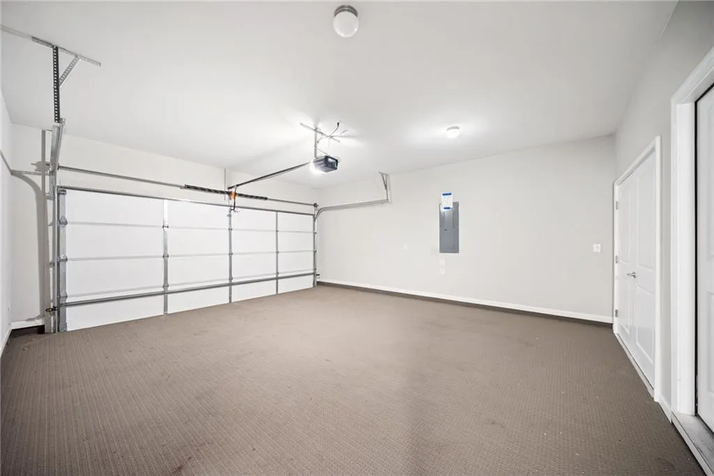 Garage with electric panel and a garage door opener
