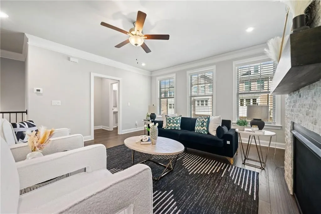 Living room with ornamental molding, dark wood-style flooring, plenty of natural light, a fireplace, and recessed lighting