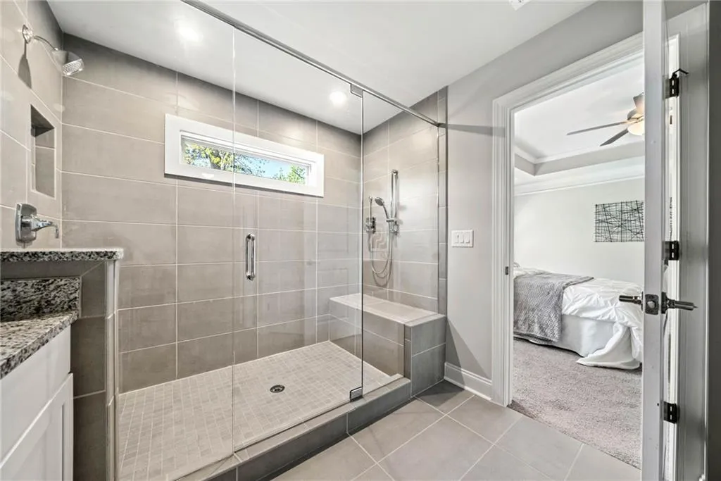 Ensuite bathroom with light tile patterned floors, a stall shower, vanity, recessed lighting, and ceiling fan