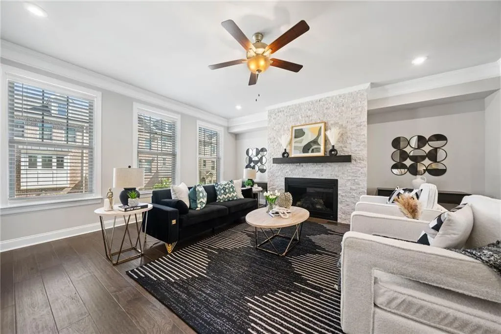 Living room featuring crown molding, a fireplace, dark wood-type flooring, a ceiling fan, and recessed lighting