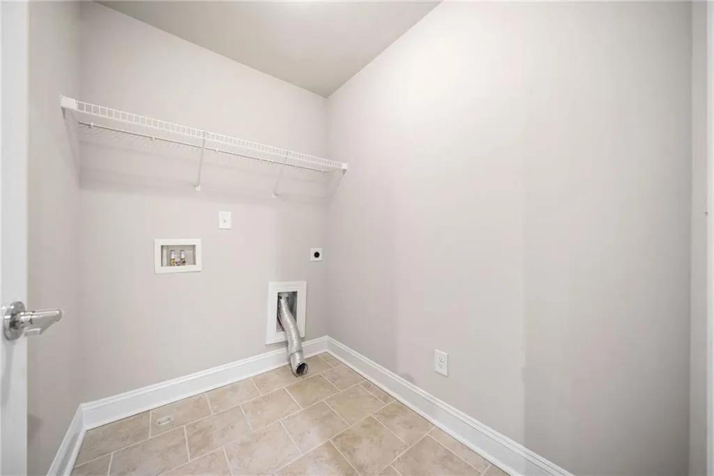 Washroom featuring electric dryer hookup, washer hookup, and light tile patterned floors