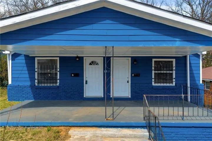 Blue exterior siding with a painted brick foundation and white trim