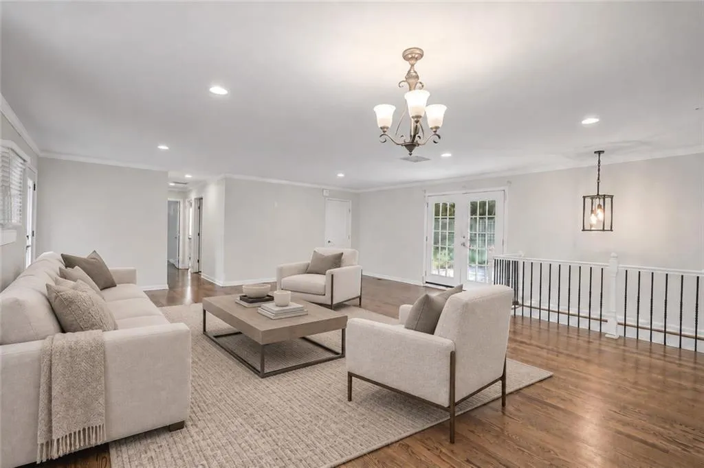 Hardwood flooring with a polished finish, recessed lighting, and a decorative chandelier