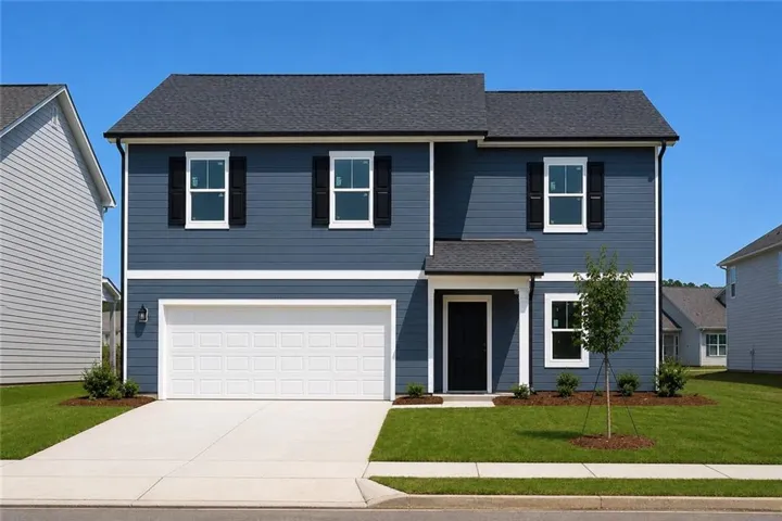 Two-story residence featuring blue siding with white trim, a dark shingle roof, a two-car garage, and a front entry door with an overhead portico