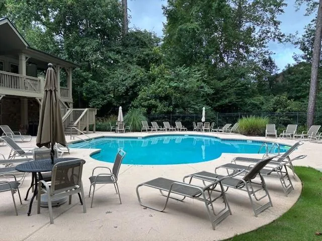 Community pool with a patio area and stairway