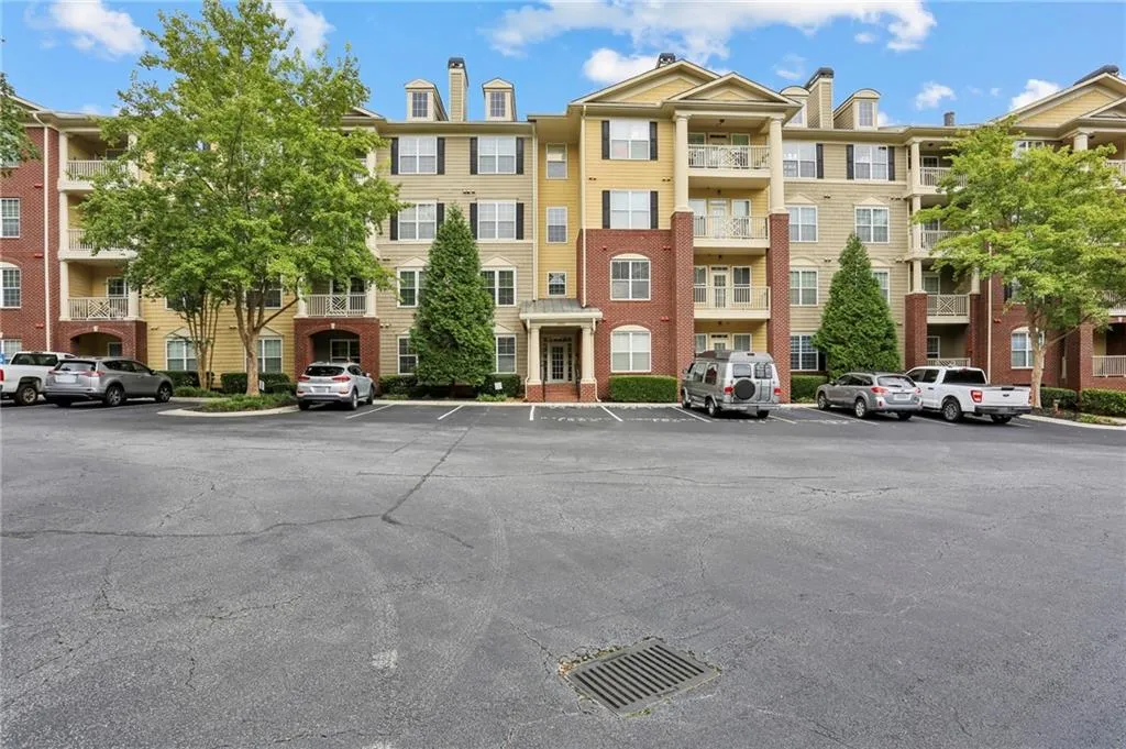 View of apartment building / complex featuring uncovered parking