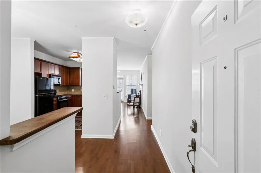 Corridor with dark wood finished floors and ornamental molding