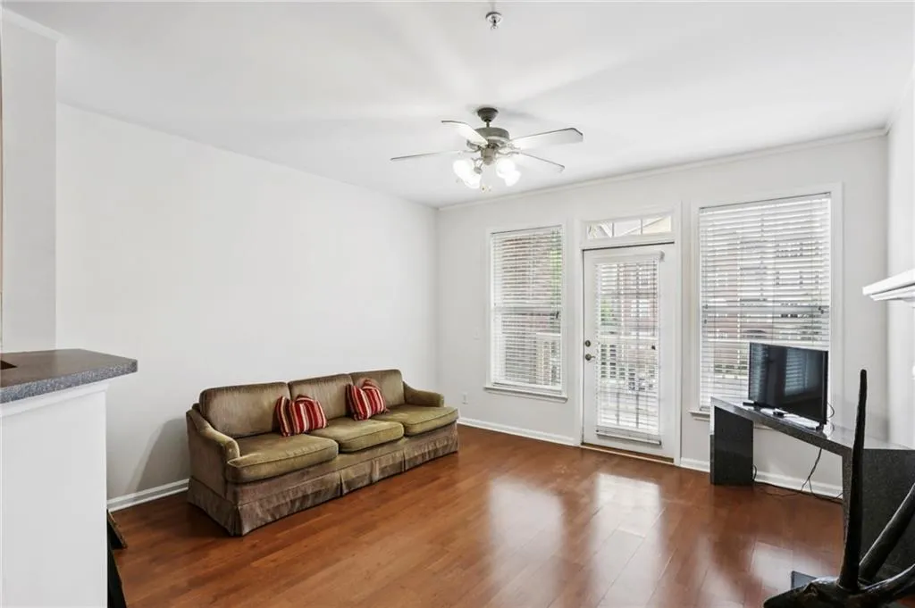 Living area featuring dark wood-style flooring and ceiling fan
