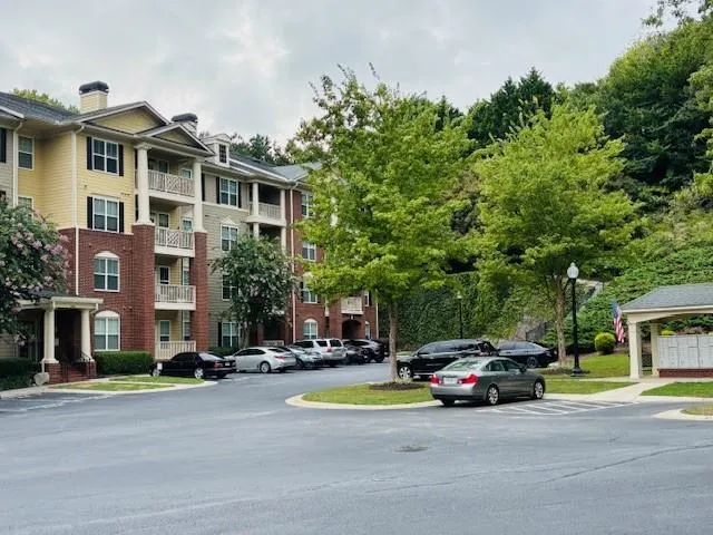 View of apartment building / complex and close mailboxes featuring uncovered parking