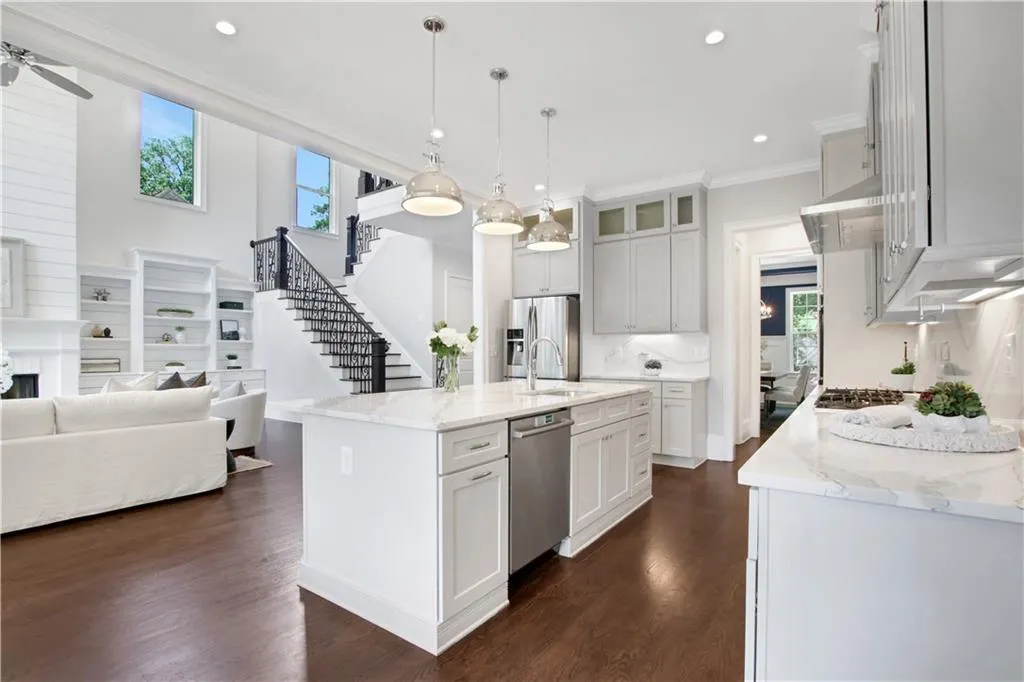 Kitchen with ornamental molding, dark wood-style floors, open floor plan, light stone counters, and recessed lighting