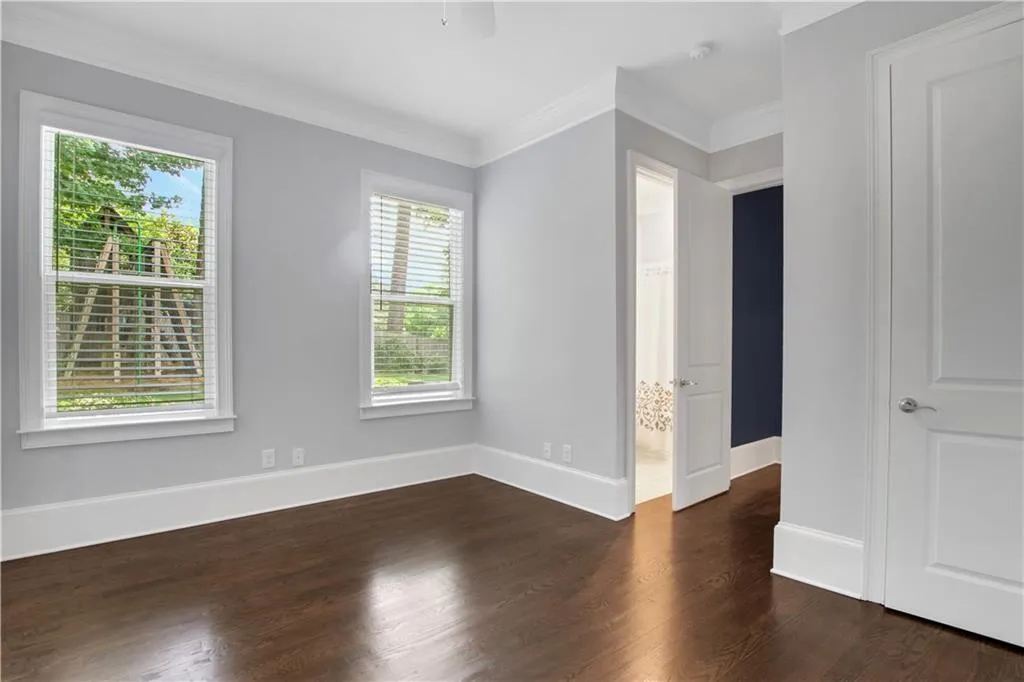 Main level guest bedroom with en suite bathroom and wood floors