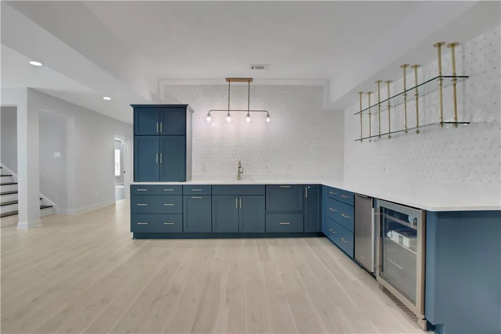 Basement wet bar with drawer dishwasher, ice machine, and beverage cooler