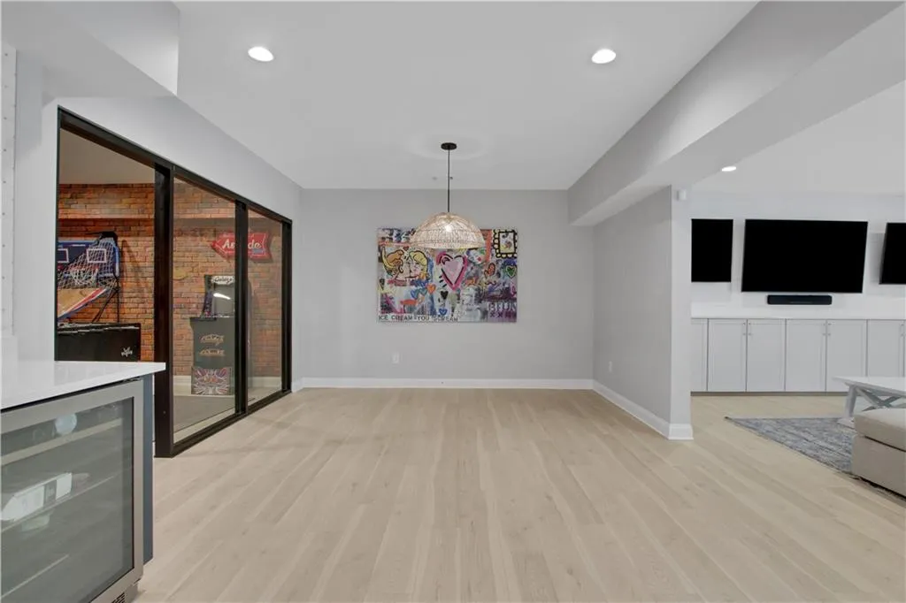 Basement dining area with beverage cooler, light wood-style floors, and recessed lighting
