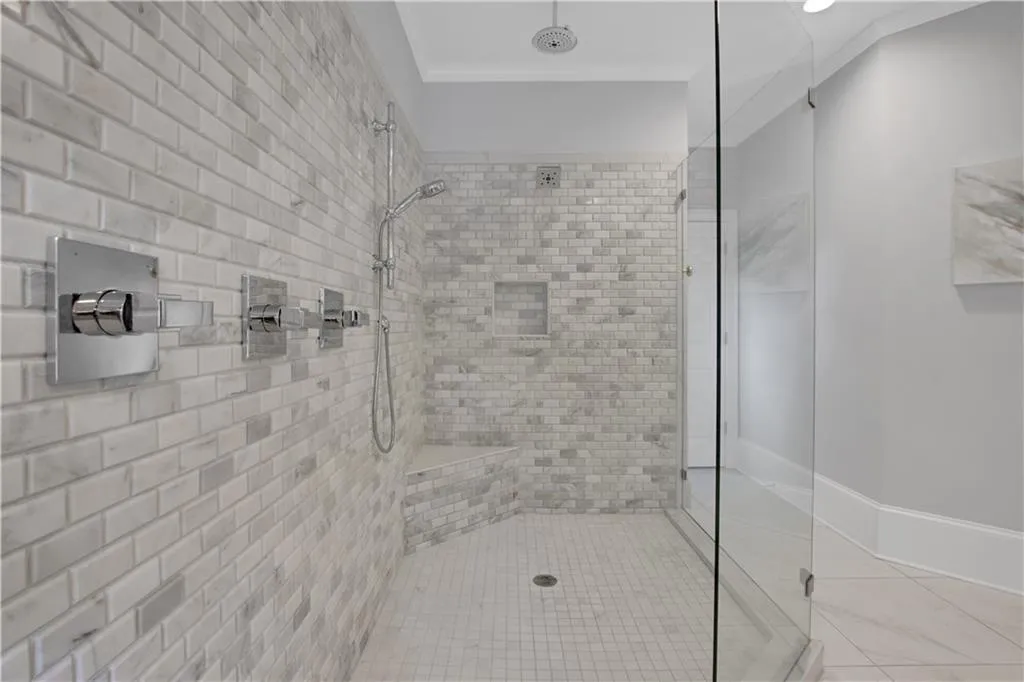 Full bath featuring a stall shower, crown molding, and tile patterned flooring