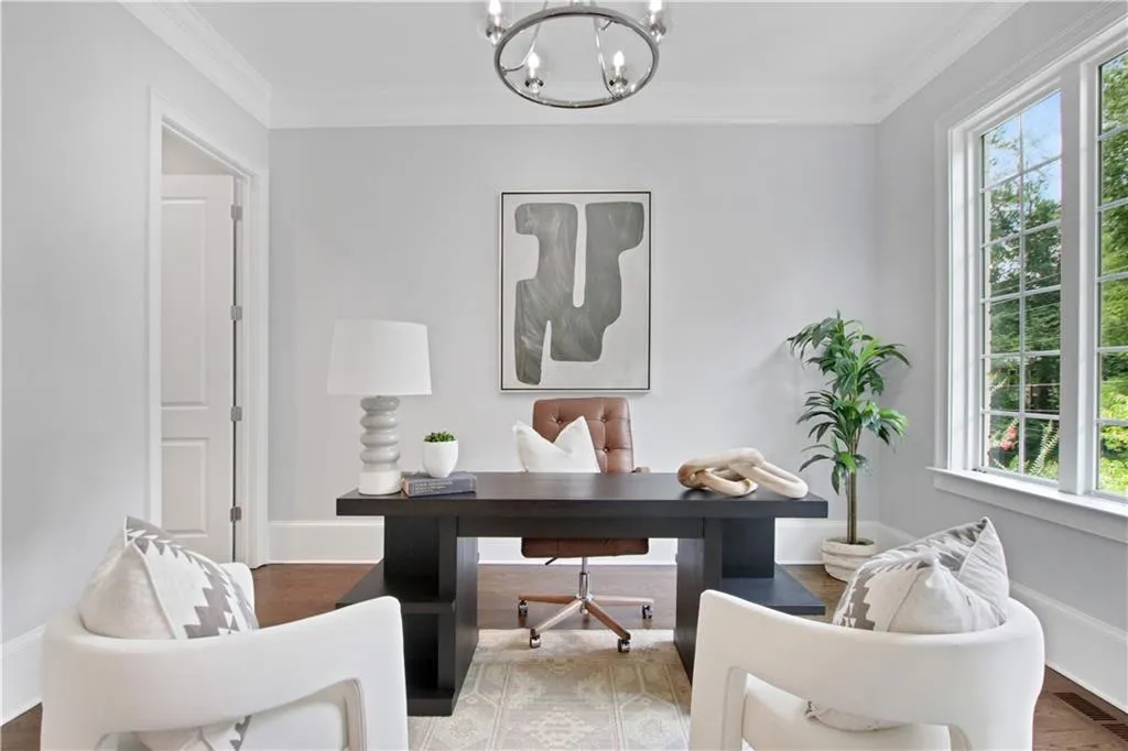 Office space with a chandelier, ornamental molding, and wood finished floors