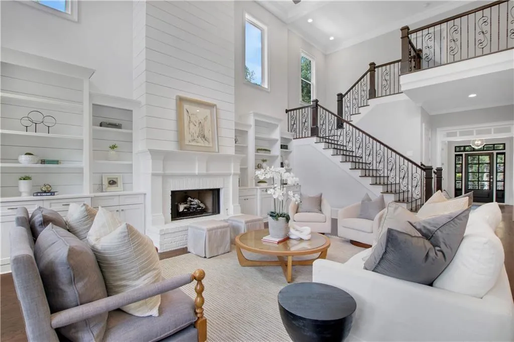 Living area featuring a high ceiling, plenty of natural light, ornamental molding, wood finished floors, and stairway