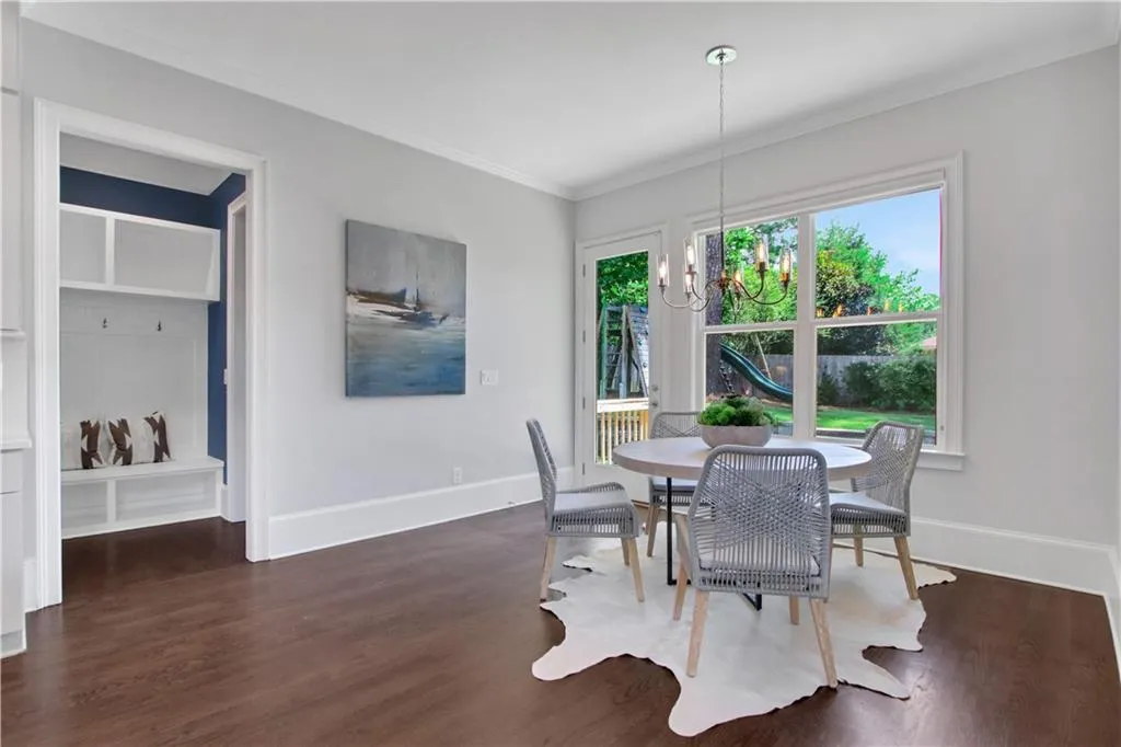 Breakfast area with a chandelier, dark wood-style flooring, and crown molding