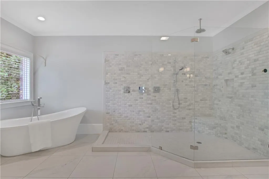 Full bathroom with a stall shower, a freestanding tub, ornamental molding, and recessed lighting