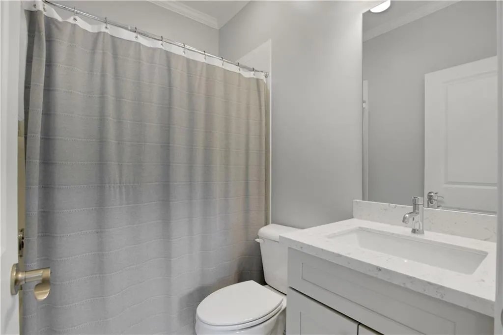 Full bathroom featuring crown molding, vanity, and a shower with curtain