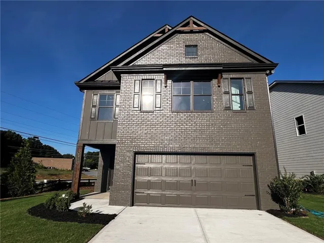 Brick and siding exterior with decorative shutters, an attached garage, and a concrete driveway