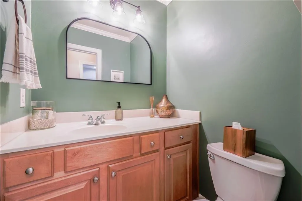 Half bathroom featuring vanity and crown molding
