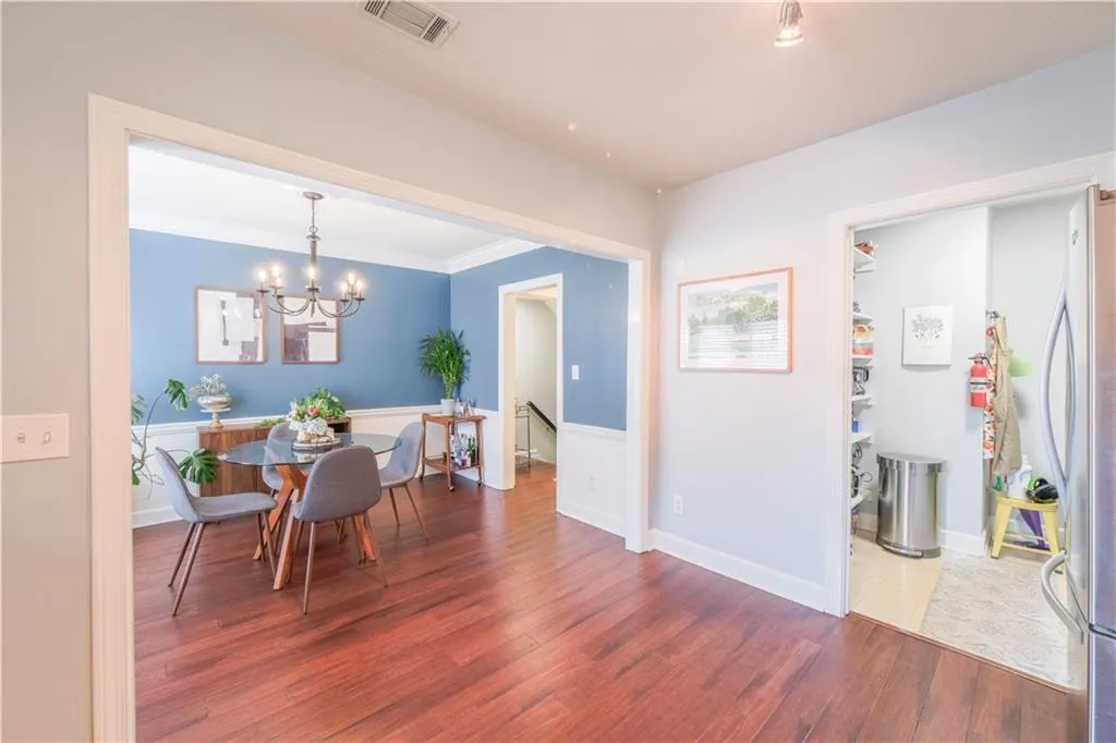 Dining room featuring wood finished floors, a chandelier, and ornamental molding