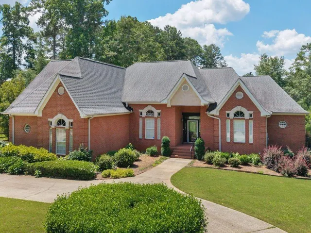 Brick exterior with multiple gables and a dark shingled roof