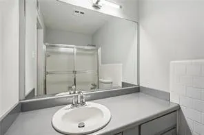 Bathroom featuring vanity and a shower with shower door