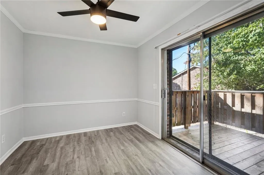 Empty room with ornamental molding, wood finished floors, and ceiling fan
